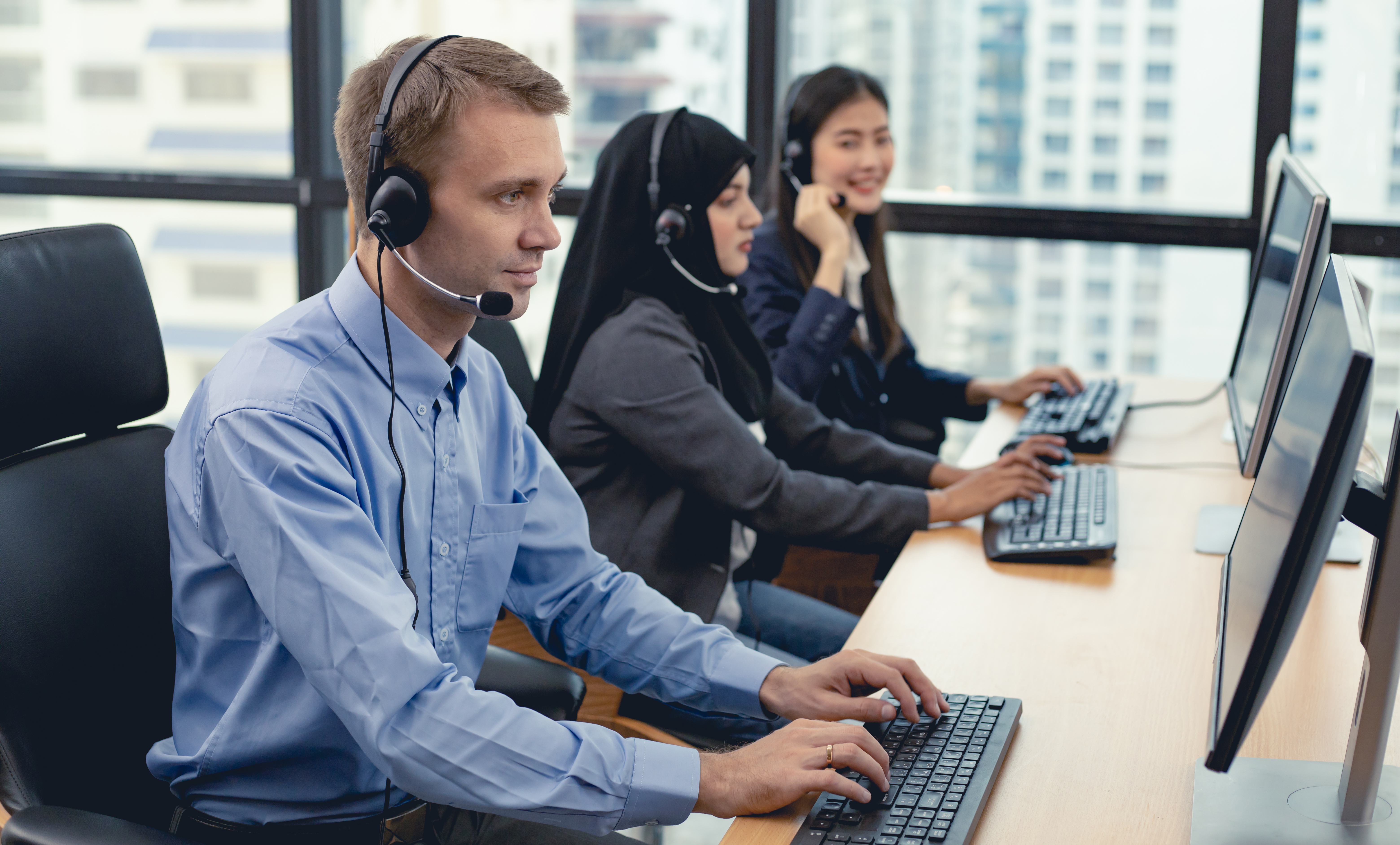 Group of diverse telemarketing customer service staff team in call center.