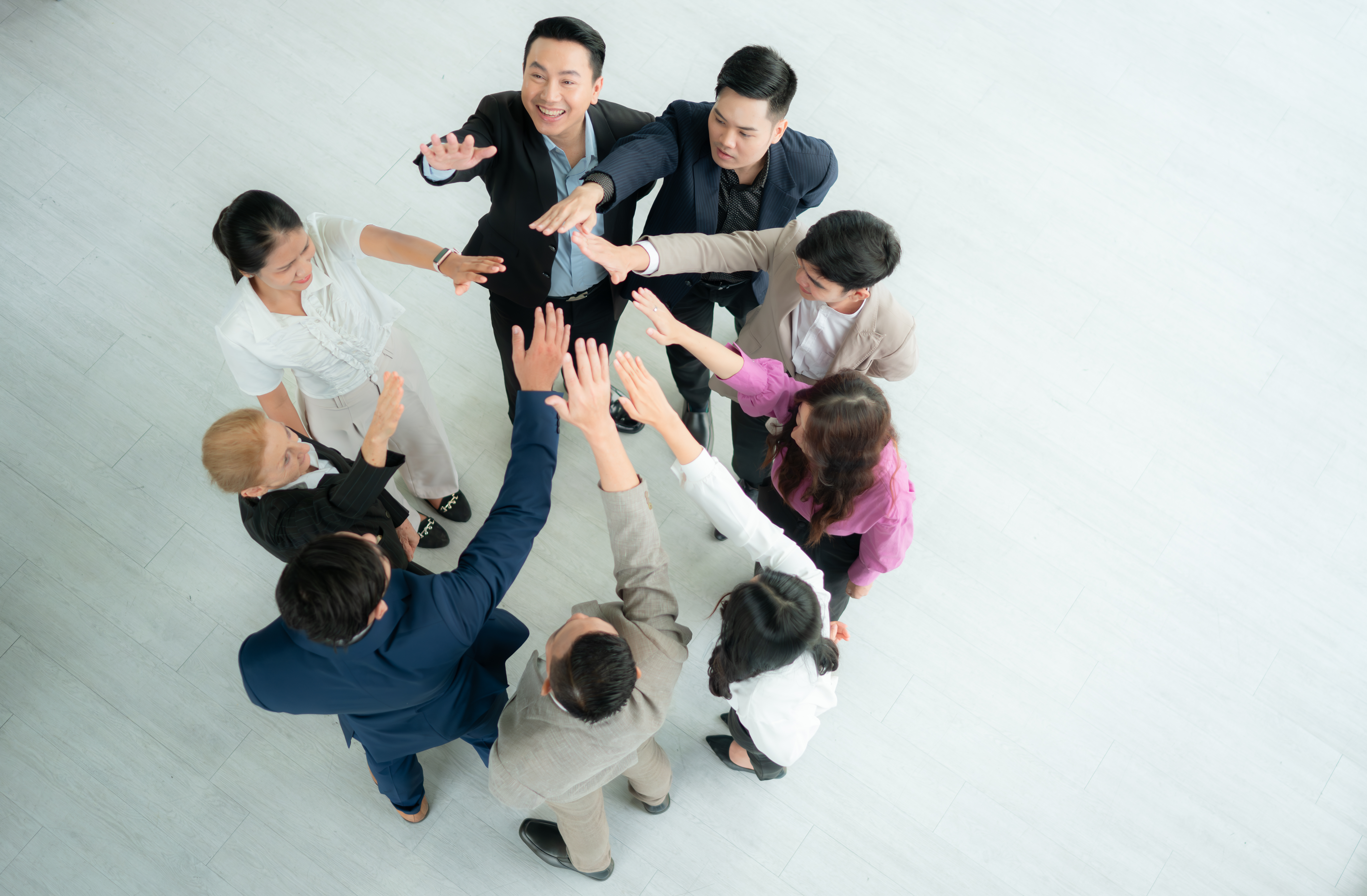 Top view of group of business people joining hands together in office to empower each other